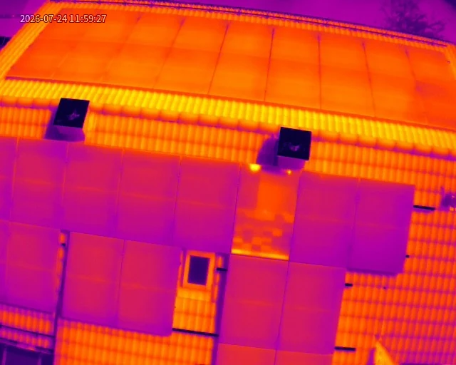 Thermografische Drohnenaufnahme einer Photovoltaikanlage mit sichtbaren Farbunterschieden und auffälligem Modulbereich